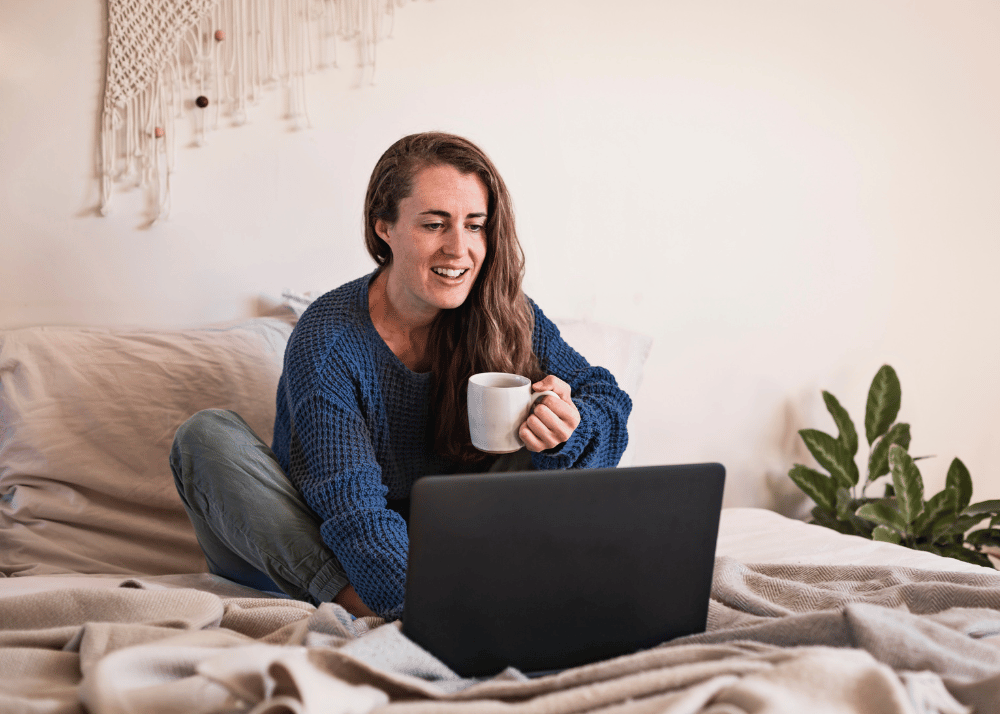 woman sipping coffee in bed with laptop, Graphic for what to do if you've been hacked?