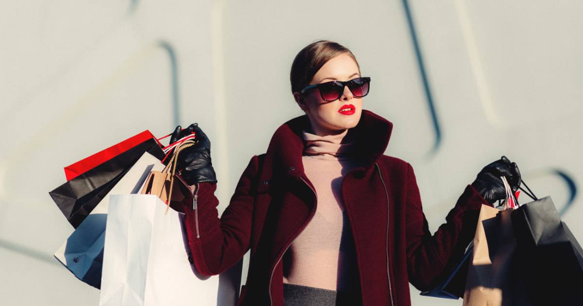 girl holding shopping bags, wearing sunglasses