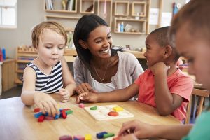 Woman playing with children at daycare