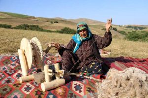 Older woman sewing in field